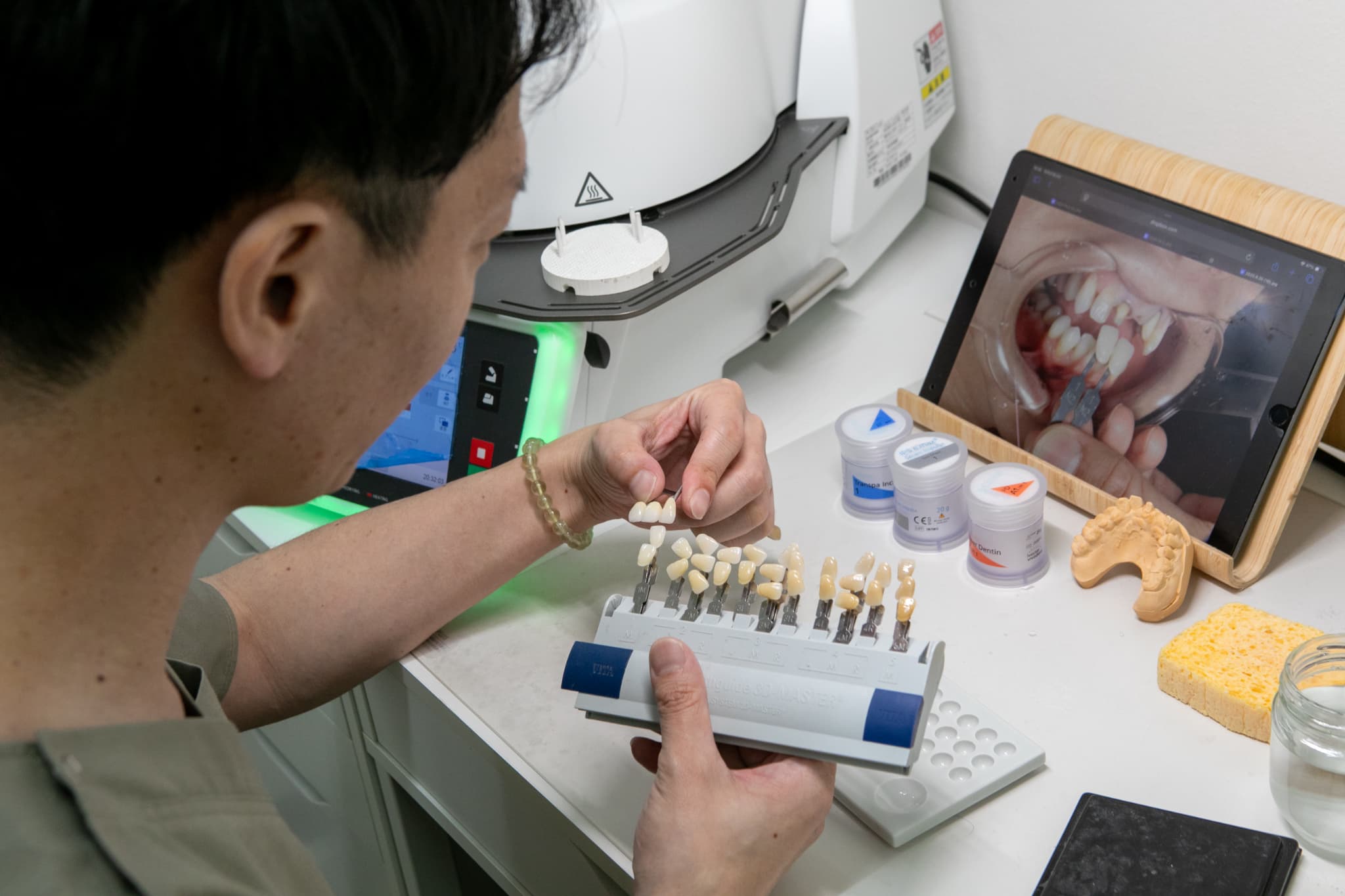 歯の模型に着色している技師