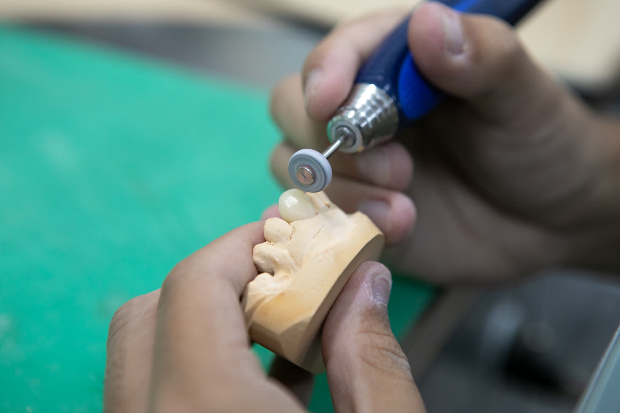 歯の模型を整える歯科技工士の手先